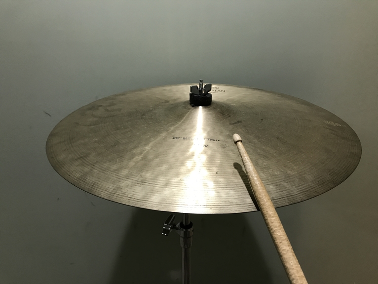 playing the cymbal on the edge with the shoulder of the drumstick