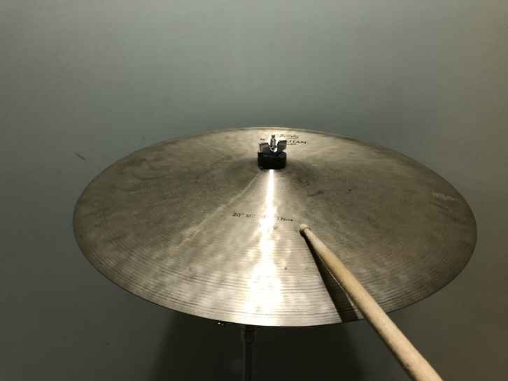 playing the cymbal on the bow with the tip of the drumstick