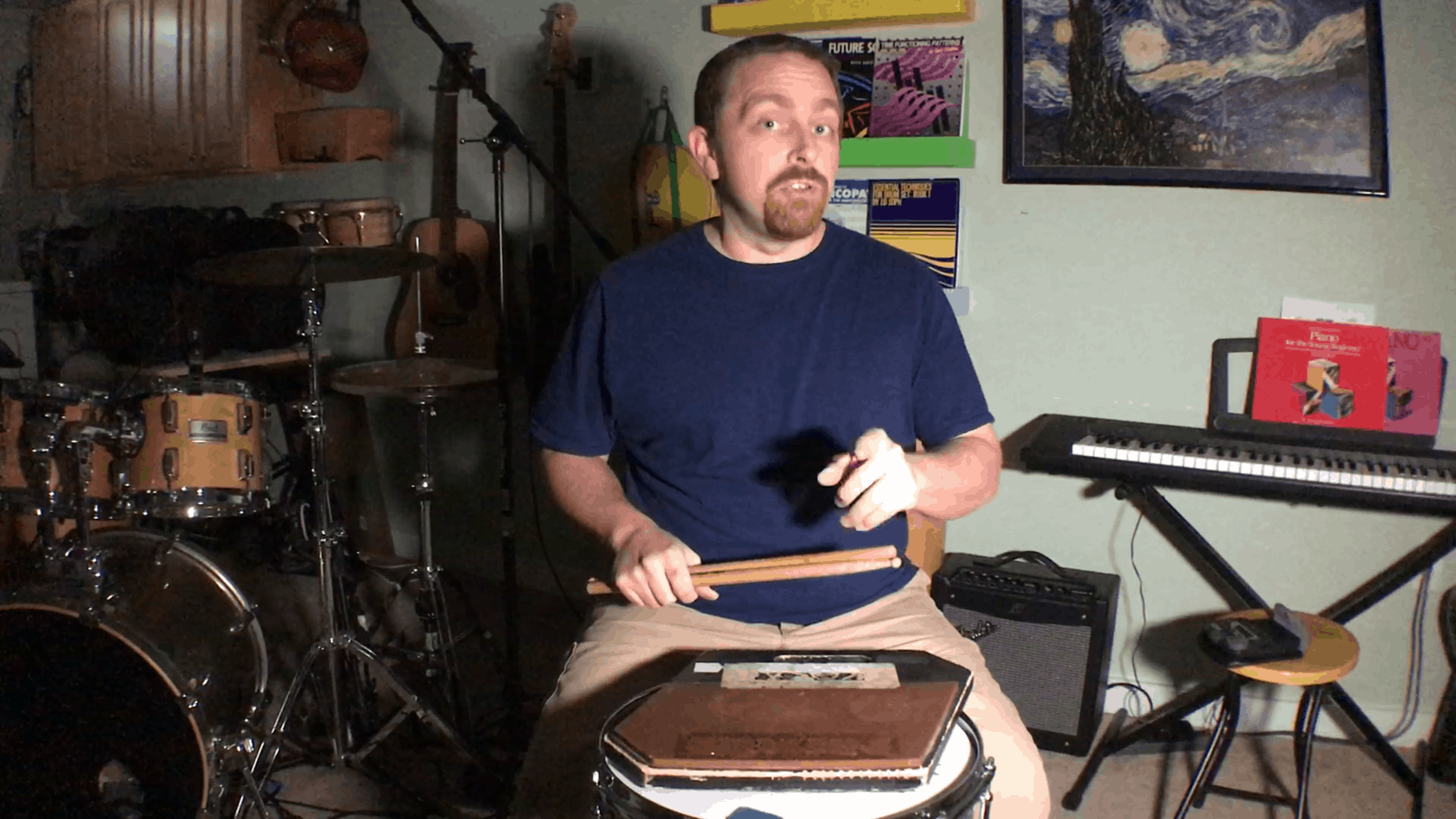 author kevin zahner sitting behind practice pad gesturing to the camera as he makes a point about practicing drums