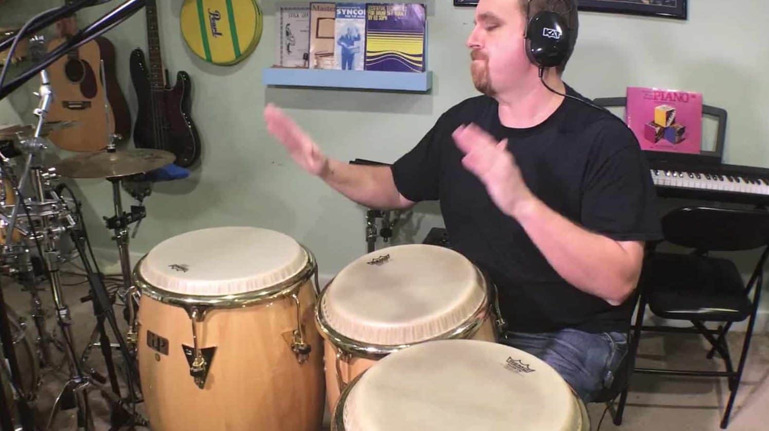 author playing three conga drums during a solo demonstration